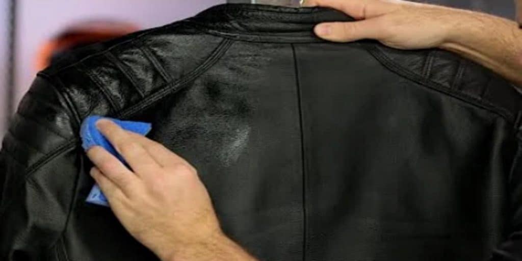 Using a sponge to work leather conditioner into the shoulders of the jacket. Conditioning restores the sheen and softness of the garment, allowing it to stretch and feel more comfortable to wear.