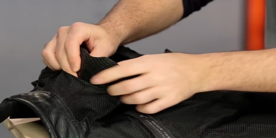 Taking out armor from back pockets before washing the garment.