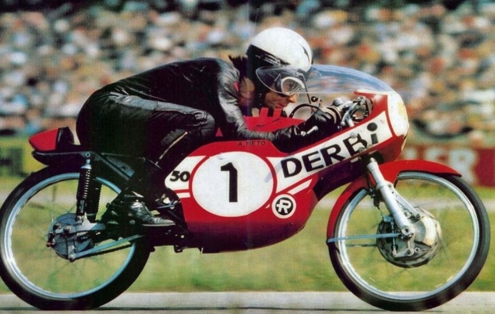 Angel Nieto, the Spanish legend and 13-time world champion, widely regarded as one of the greatest motorcycle racers in Grand Prix history, can be seen riding his iconic red Spanish DERBI–the bike he rode for most of his career while sporting a variety of models of AGV Helmets.