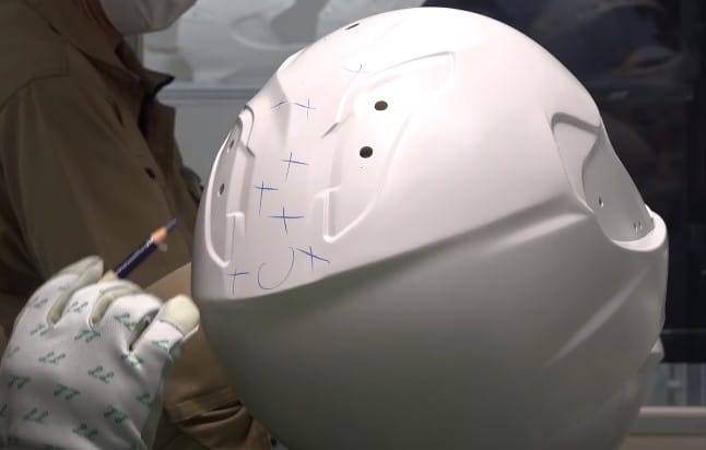 Technologist at Shoei marks up parts of the helmet shell that need correction to meet spec during quality control inspection. Each helmet has to undergo numerous quality control checks to ensure that it is absolutely in spec before it can leave the factory.