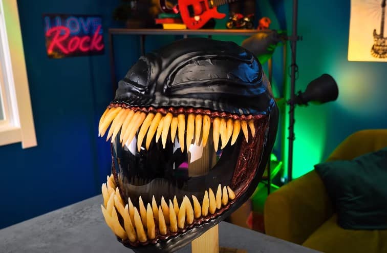 An expired motorcycle helmet ingeniously transformed into a spine-chilling Venom mask, boasting a striking and eerie custom design.