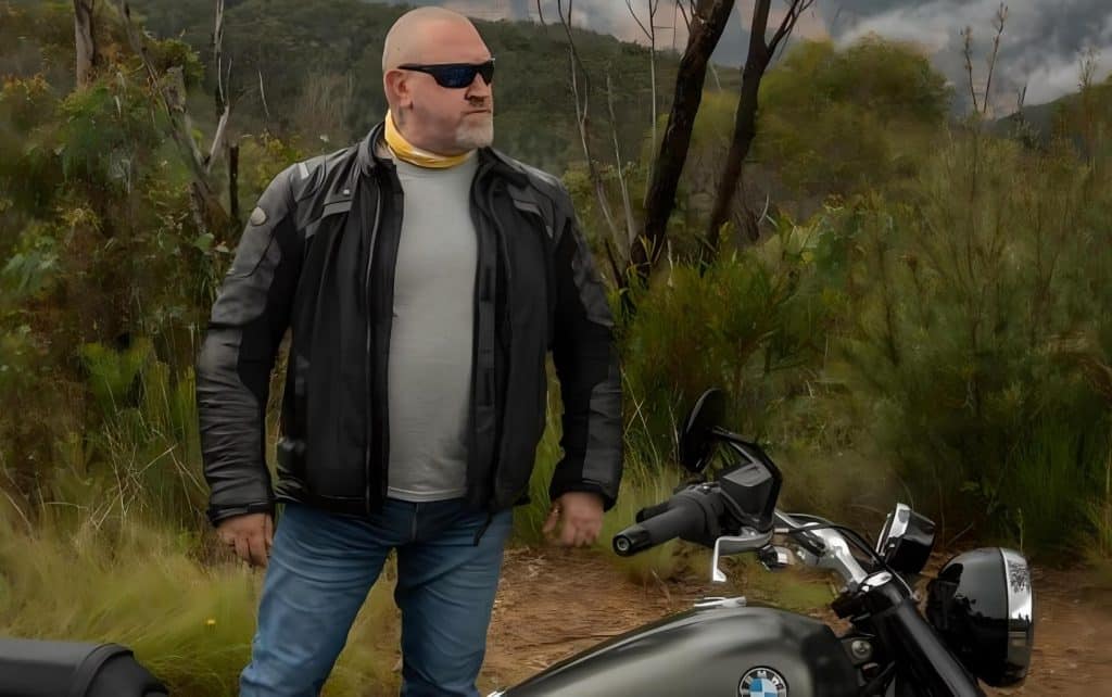 Boris stands beside the parked BMW R 18 Classic Highline R 18 on the shoulder of Goulburn-Oberon Road, a thoughtful expression on his face, as if pondering, 'Hmm, that truck nearly hit him. He should be more careful.' In a road rage situation, would you choose to stop and confront this man?
