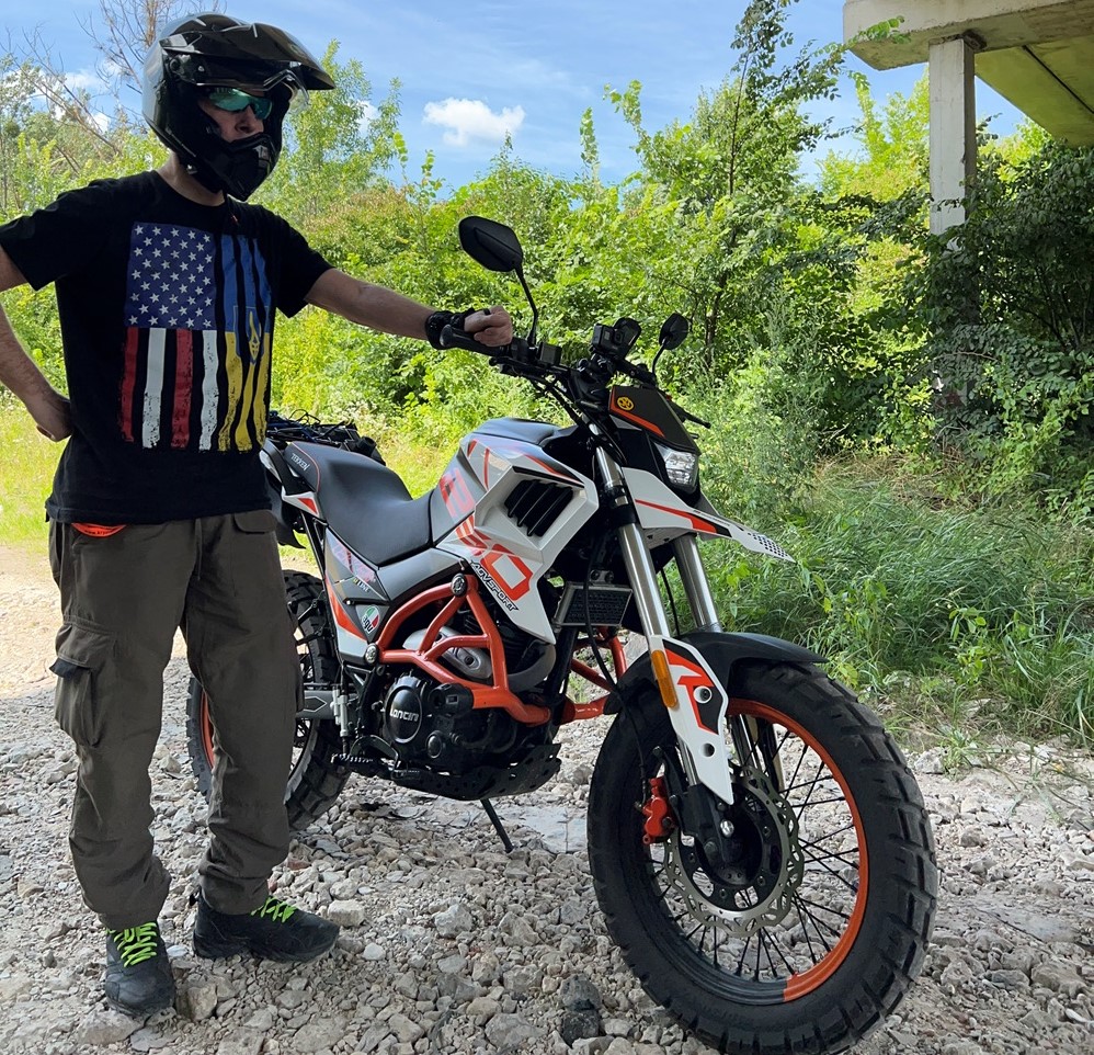 I, Michael Parrotte, standing proudly next to my Tekken 250 adventure touring motorcycle, donned in an ECE and DOT-certified AGV AX-9 Matte Carbon helmet.