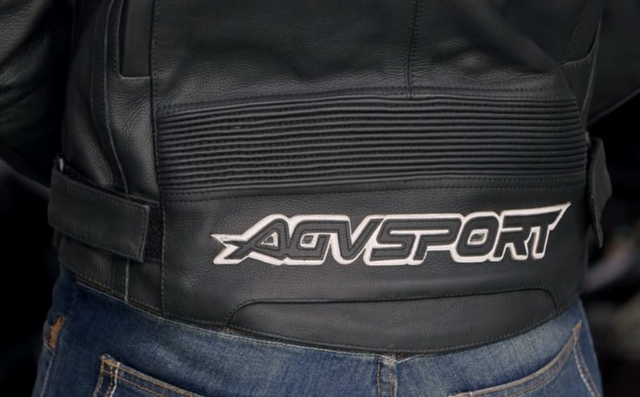 The backside of the AGVSPORT Arogan leather motorcycle jacket showing the stretch zones near the lower back that allow the garment to fit snugly, covering the beltline while standing and riding.
