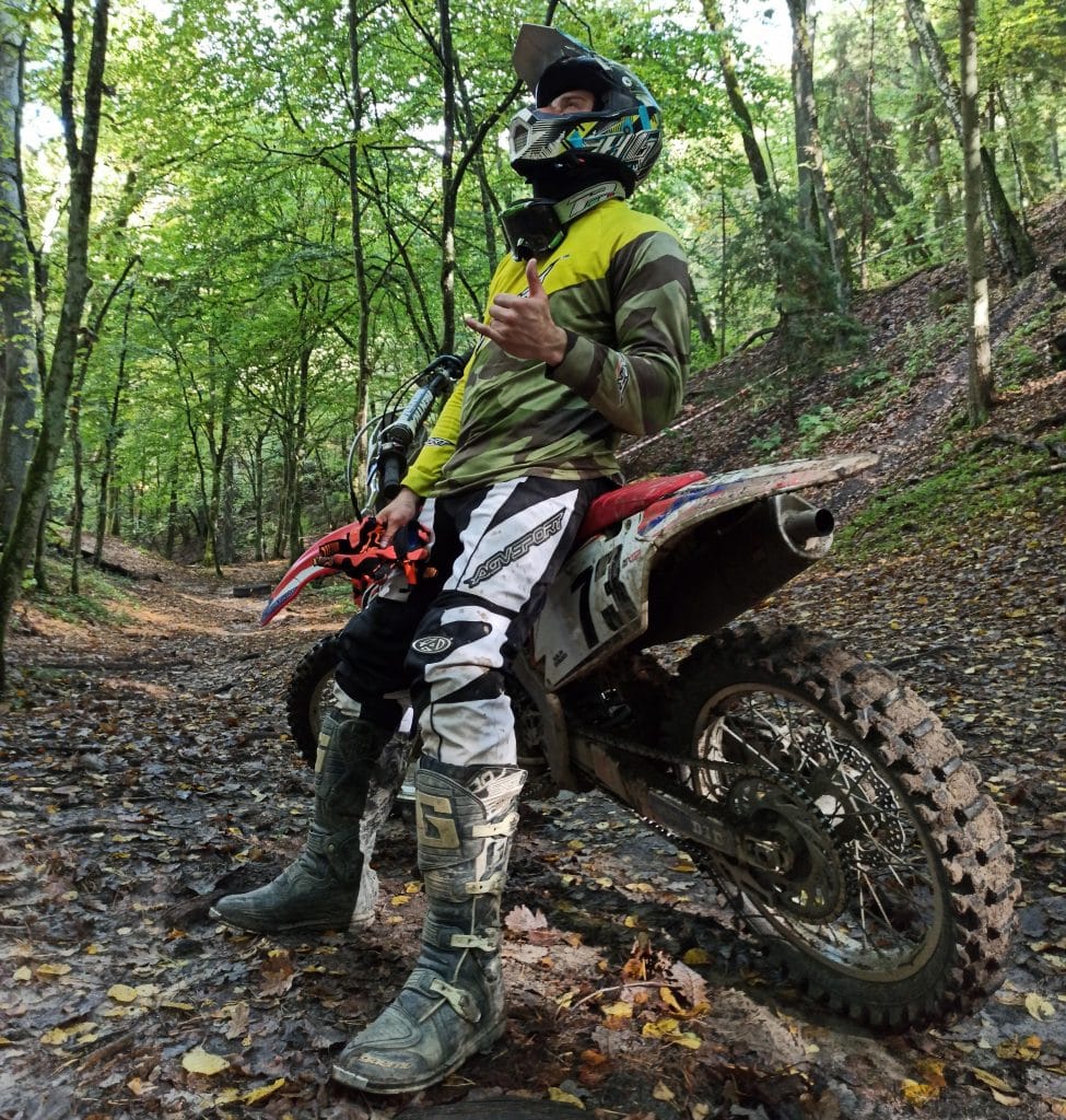 Sporting neon yellow AGVSPORT reflective motorcycle clothing to enhance visibility, even amidst mud splatters. Mounting the GoPro on the AGV AX-8 helmet provides an excellent trail view without compromising awareness of terrain depth, and the tall ADV boots serve as a crucial injury prevention measure. Need tall motorcycle boots