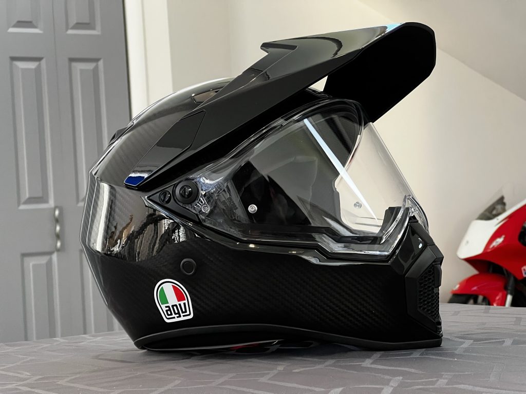 The Matte Black AGV AX-9 helmet with a panoramic, Pinlock-ready visor displayed in a Maryland office setting. 