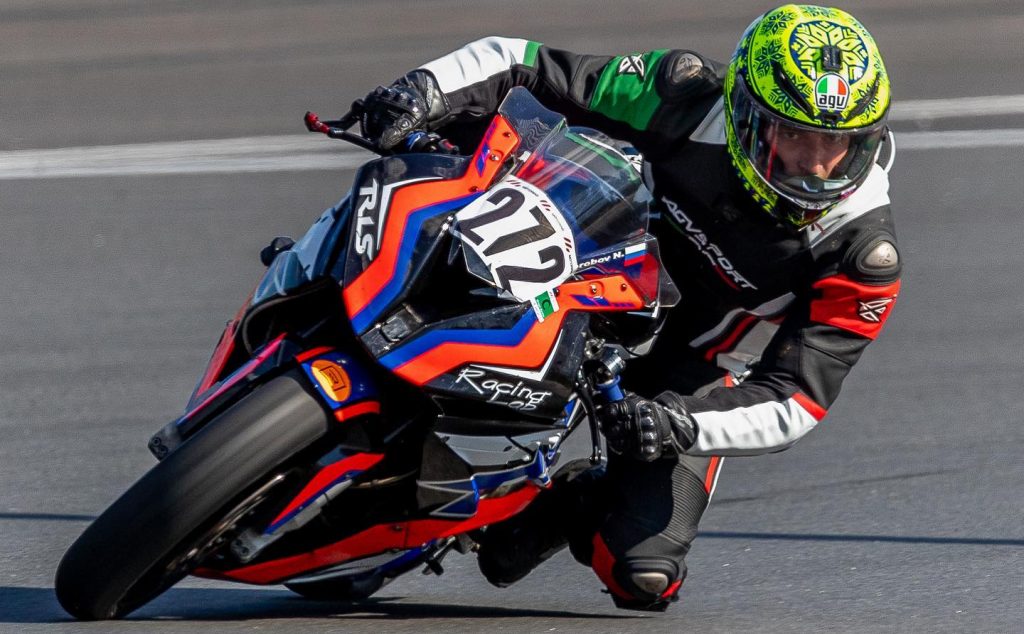 The AGV K1 Winter Test 2017 helmet demonstrates its aerodynamic design, including racing-developed front air vents and an aero spoiler crafted in wind tunnels, which boost performance and stability during high-speed rides. Witness it in action as AGV-sponsored stunt rider Denis Grachev races on a BMW S1000R at the Sochi Autodrom race track in Russia.
