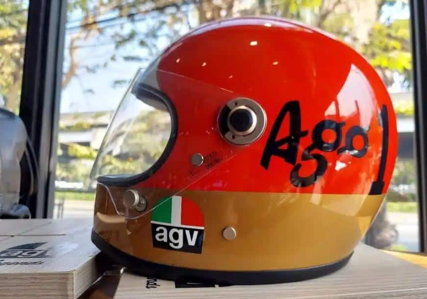 AGV X3000 "Ago 1" fiberglass motorcycle helmet featuring a retro racing design and a strong, lightweight fiberglass shell for durability and impact protection.