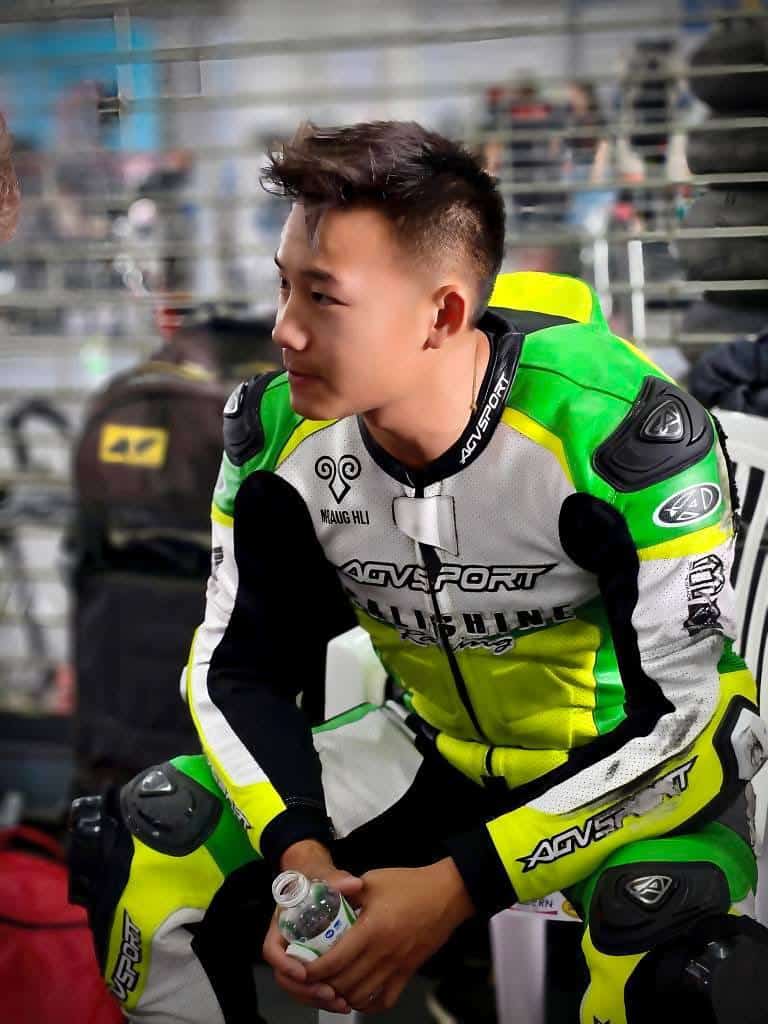 The AGVSPORT custom racing suit showing visible signs of impact abrasion on the left arm. The outer leather surface displays scuffing and wear consistent with a slide, highlighting the suit’s abrasion resistance and reinforced protection.