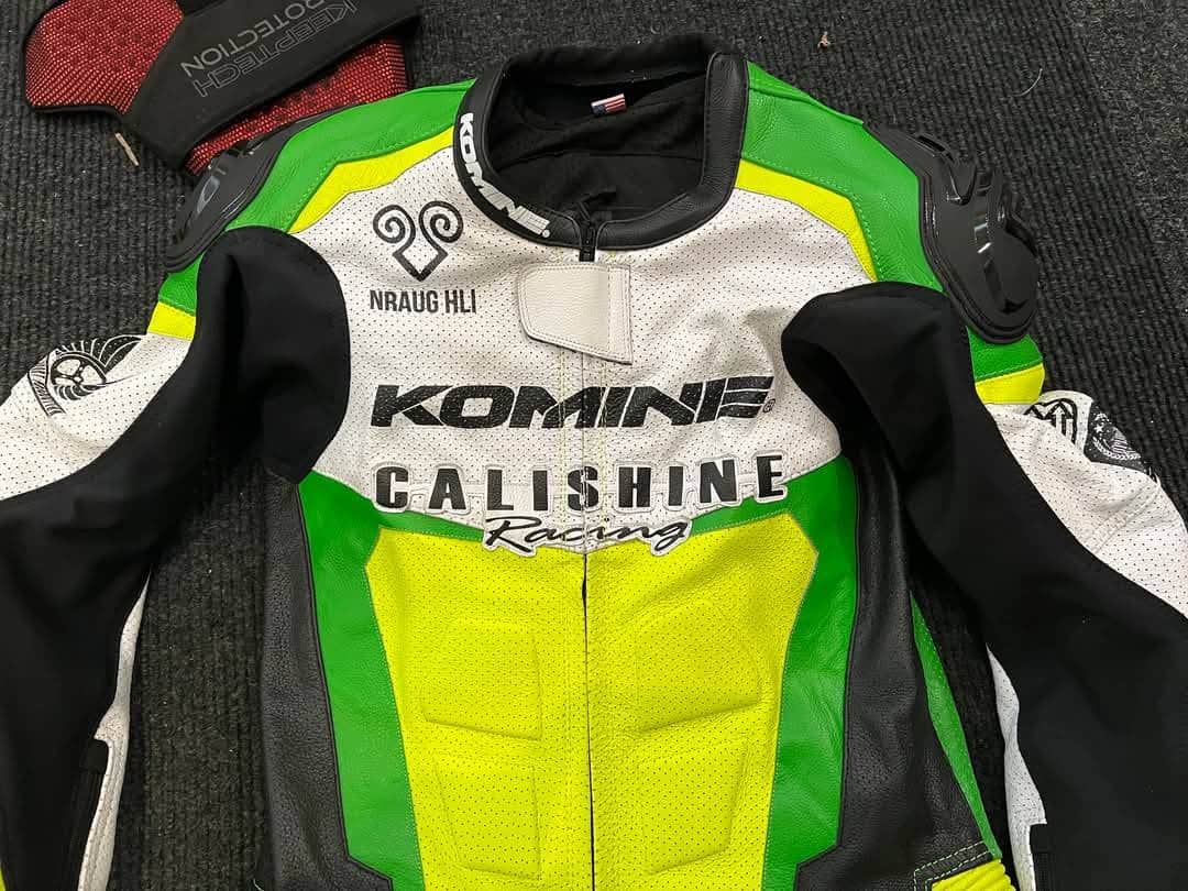 Close-up of the Komine custom racing suit highlighting key risk zones. High-impact areas including shoulders, elbows, knees, and hips are reinforced with CE Level 2 armor. Abrasion zones on the forearms, thighs, and seat feature extra layers of leather and stretch Kevlar panels, while ventilation points and accordion stretch zones enhance mobility and comfort.